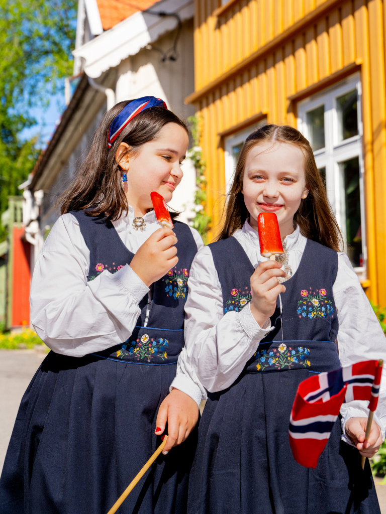 Gilrs in bunads eating ice cream. Photo: Fredrik Ahlsen/Maverix Media AS Fredrik Ahlsen_Maverix Media AS